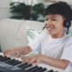 Boy playing piano at a keyboard.